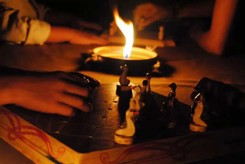 Una partita a un gioco medievale illuminata da una fiamma